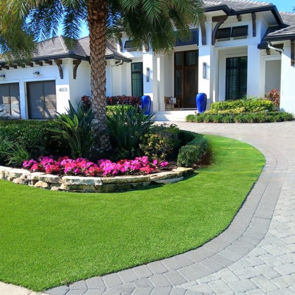 Artificial turf, annual color, cut caprock retaining wall | Love's Landscape Landscape Installation & Maintenance Company
